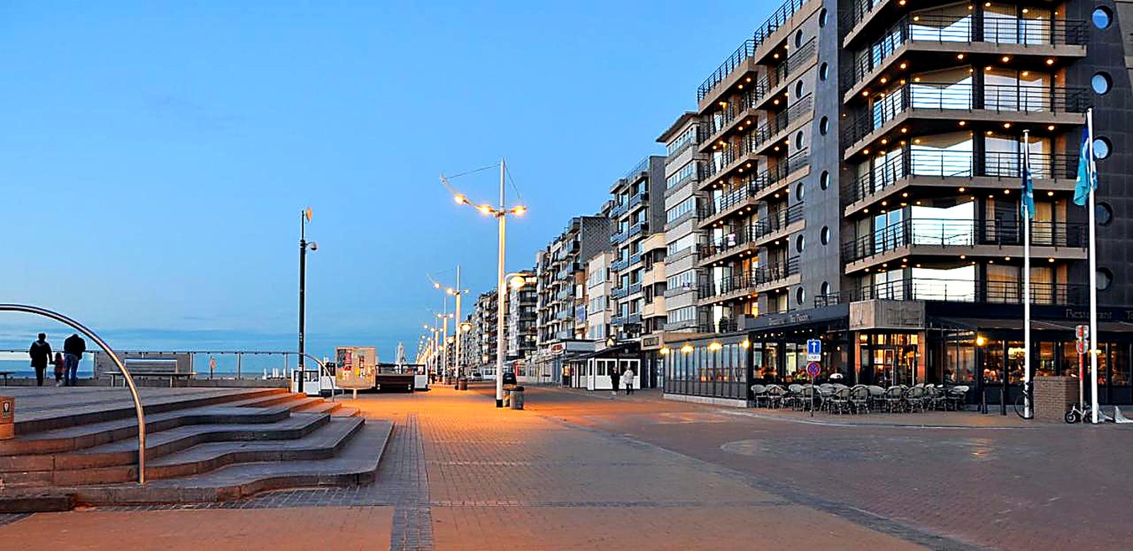 La digue et la promenade de Coxyde-Bains au crépuscule, immeubles en bord de mer sur la côte belge